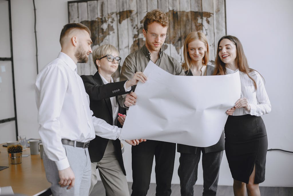 Group of professionals in an office setting analyzing project plans together.